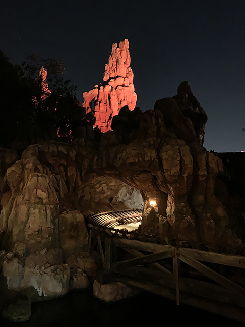 an image  of a red rock hill at night with a train tunnel
