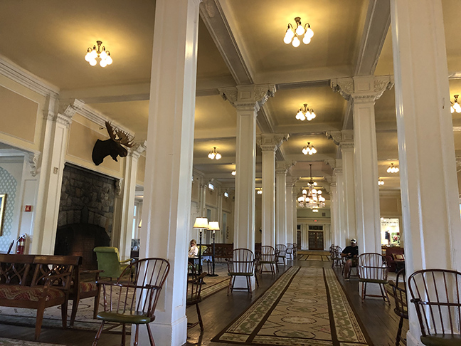 a huge hotel lobby with wooden white pillars going into the distance
