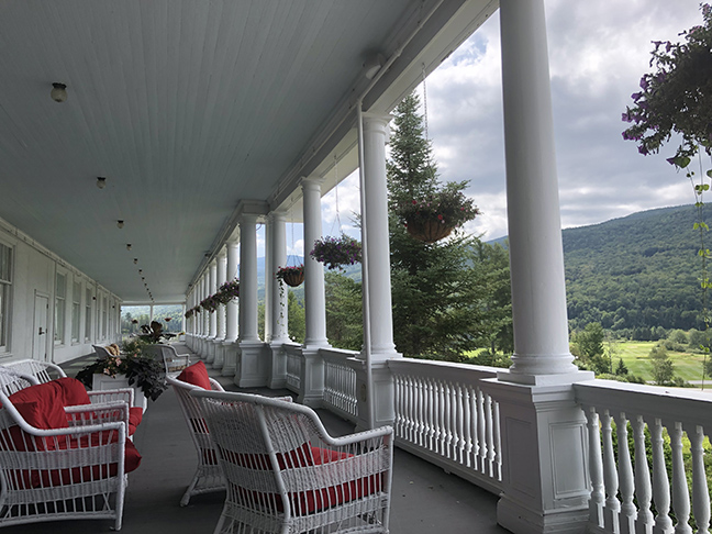 a very large Victorian style porch with white posts going into the distance