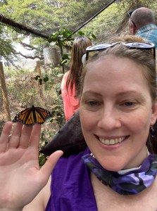 me holding a monarch butterfly in my hand and smiling, wearing putple