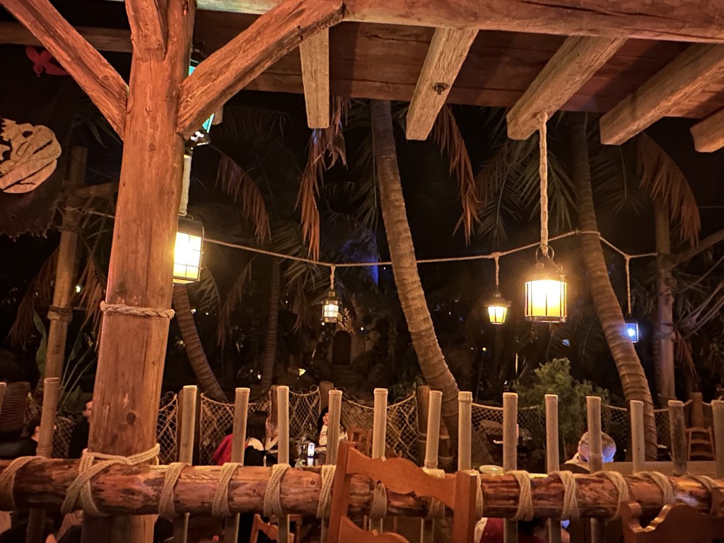 A rustic nighttime roofed dock with lanterns