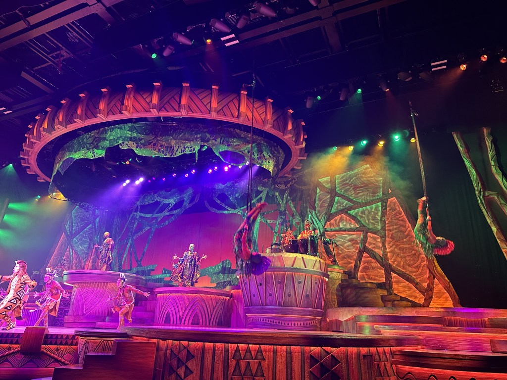 A very colorful stage show with acrobats on bungee cords
