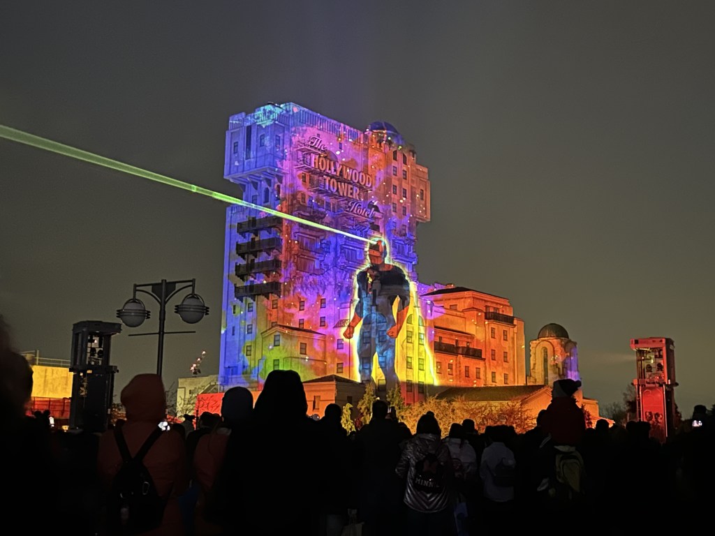 Image of the Hollywood Tower Hotel (Tower of Terror ride) with Vision protected onto it and a green laser coming from his head and shooting off to the left.