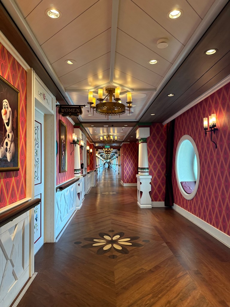 a picture of a long hall with chandeliers and portraits