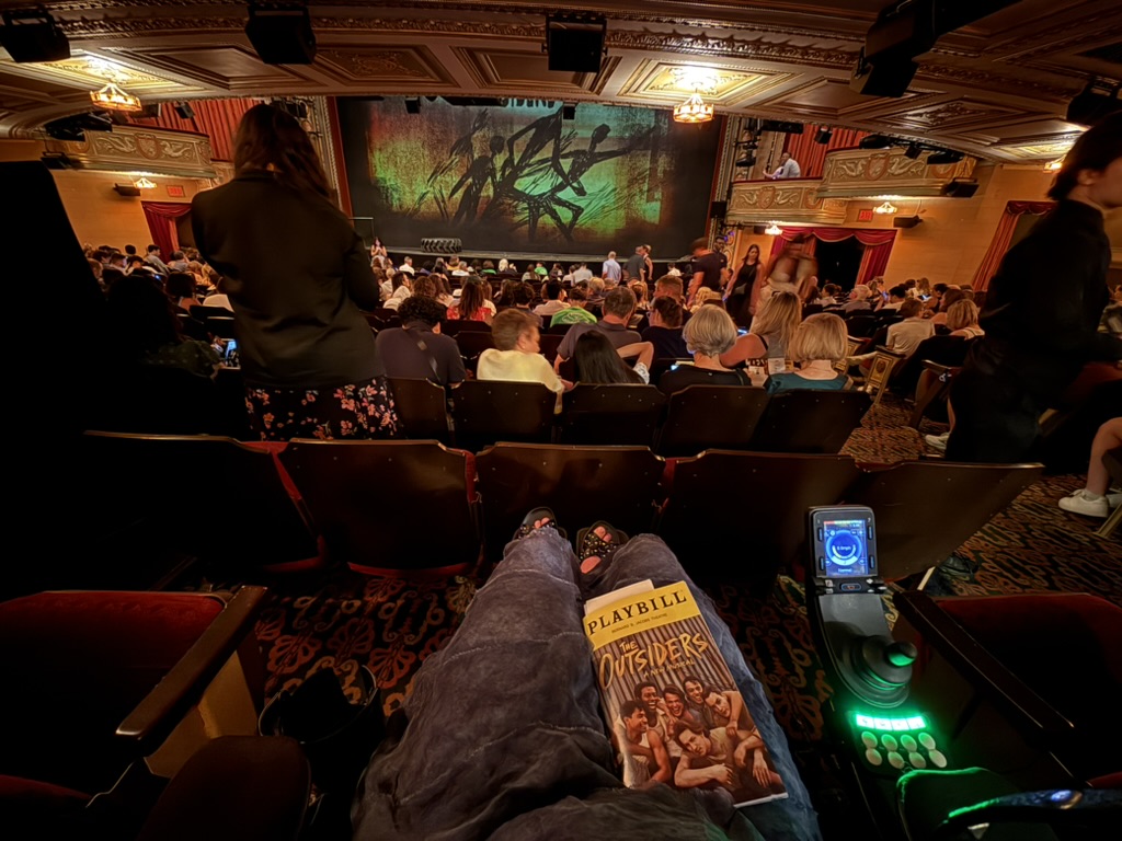 A picture of the theatre from the seat for the Outsiders with playbill